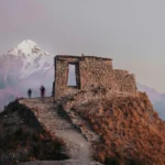View of Intipunku in front of snow-capped mountains.